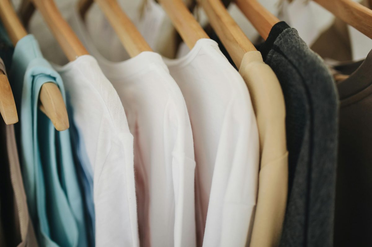 Prendas de uniforme colgadas en un perchero, con el portal digital de pedidos de Uniforms Flow